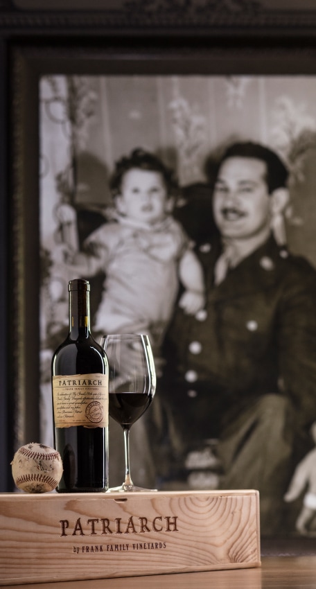 A black and white family photo sits next to a bottle of Frank Family Vineyards Patriarch Wine.