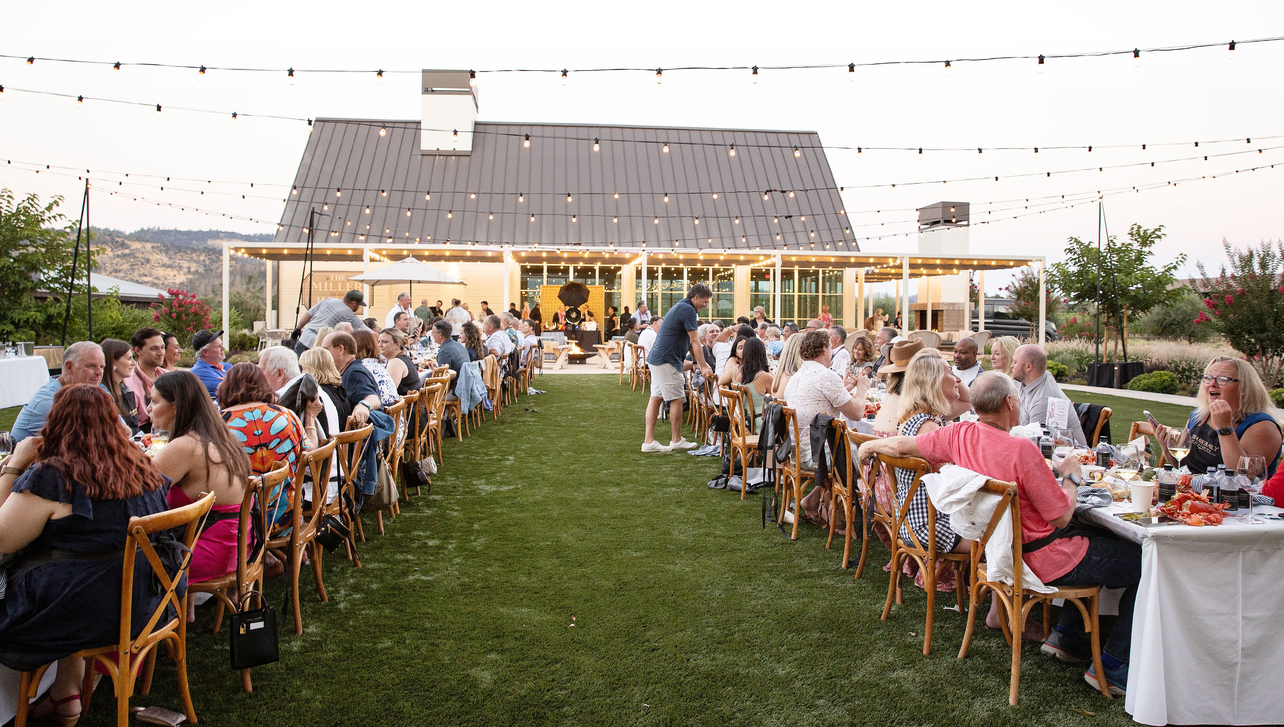Harpist is playing at a wine tasting with patrons enjoying their meals.