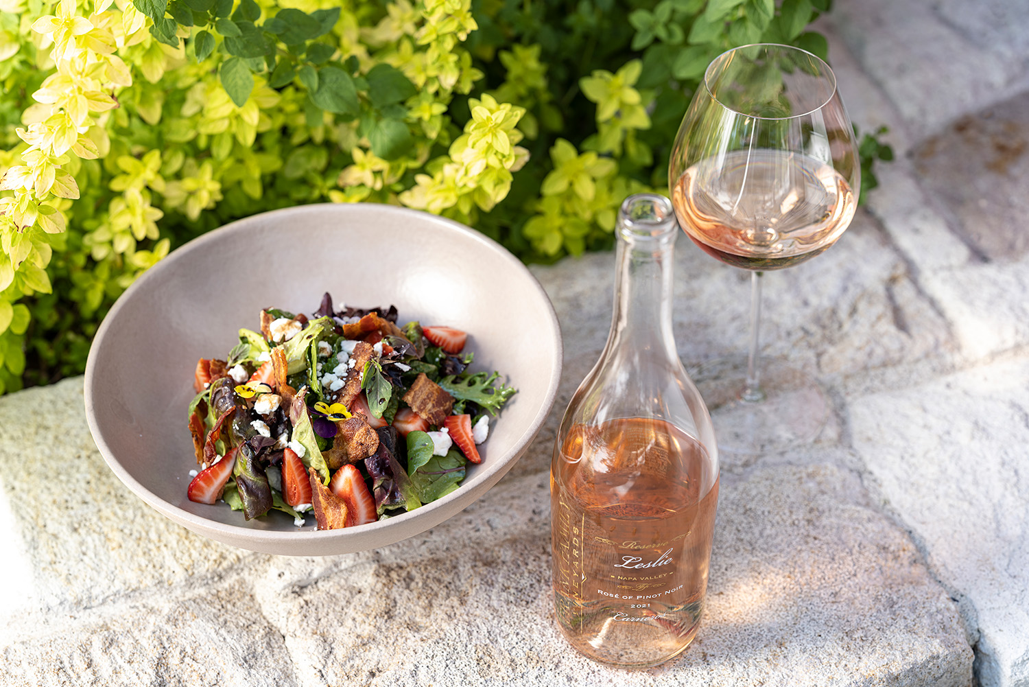 Strawberry and Bacon Salad next to a bottle and glass of Frank Family's Leslie Rosé