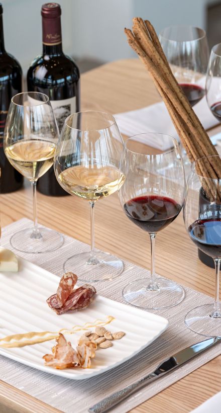 A plate of artisanal cheeses and meats sit beside a lineup of Frank Family wines