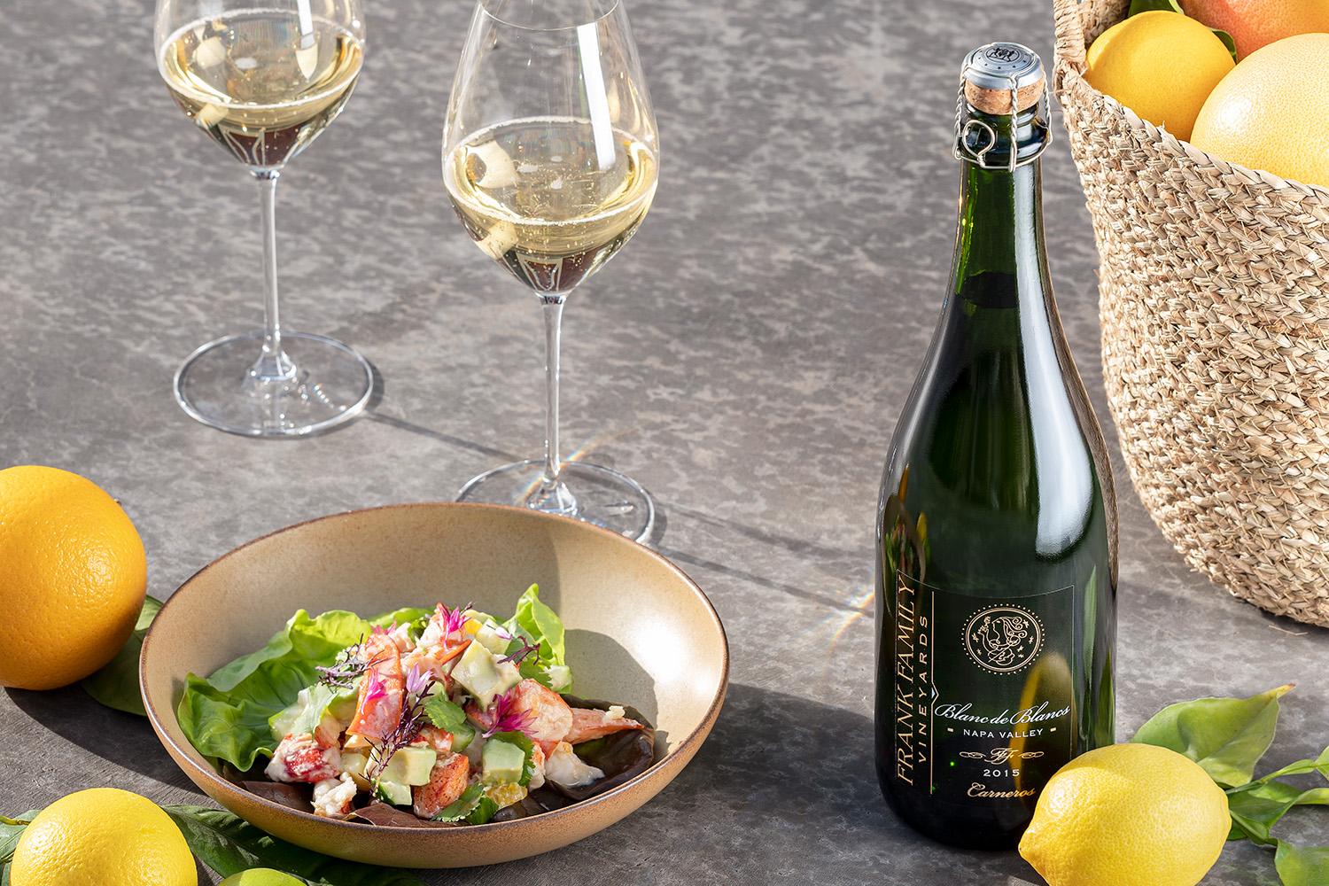 Lobster salad beside two glasses of Blanc de Blancs and fresh lemons