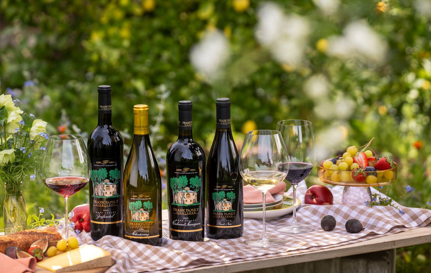 A collection of Chardonnay, Pinot Noir, Zinfandel, and Cabernet set against a lush spring garden.