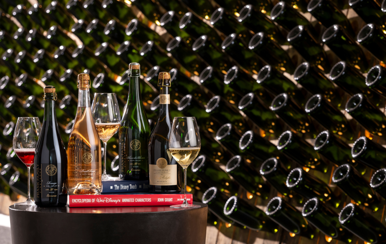 An assortment of Frank Family sparkling wines against a riddling rack.