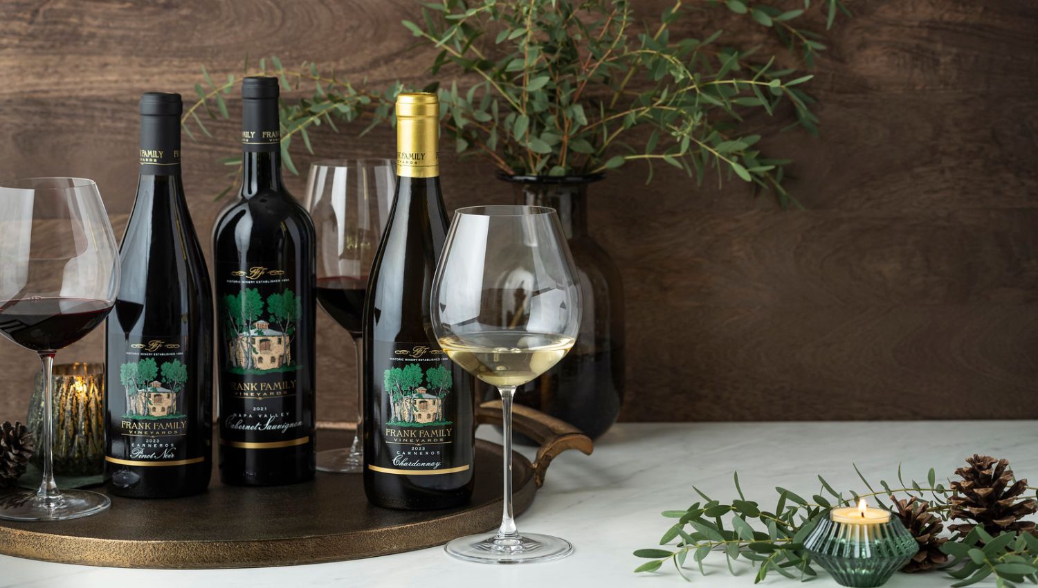 A collection of Chardonnay, Pinot Noir, and Cabernet in a rustic, holiday setting