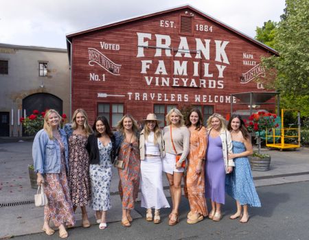 A group of ladies smiling in front of Frank Family's Red Barn.