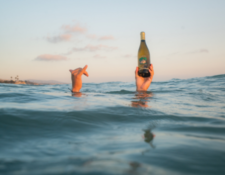 A bottle of Frank Family Carneros Chardonnay held above water. 