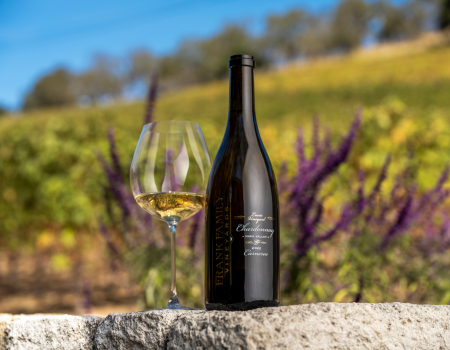 A bottle of Frank Family's 2022 Lewis Vineyard Chardonnay next to a poured glass. 