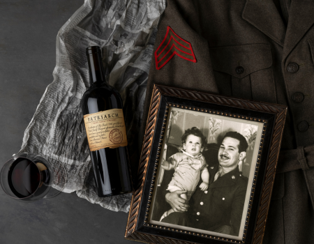 A bottle of Frank Family's Patriarch Cabernet posed next to a photo of young Rich Frank and his father, Hy Frank, who Patriarch is made after. 