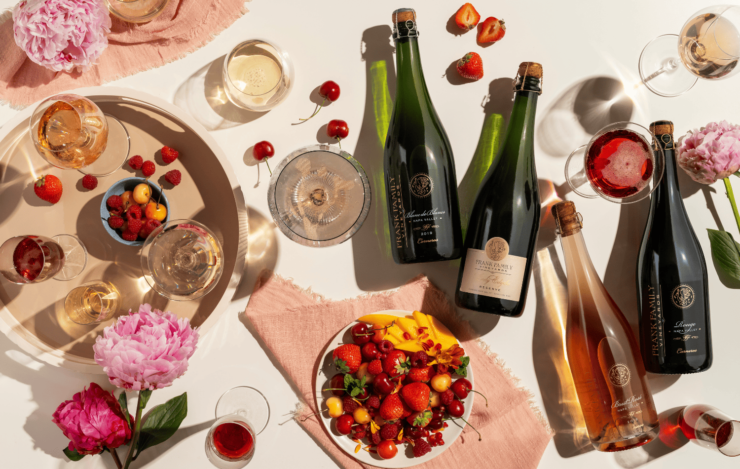 An assortment of Frank Family sparkling wines alongside fresh fruit.