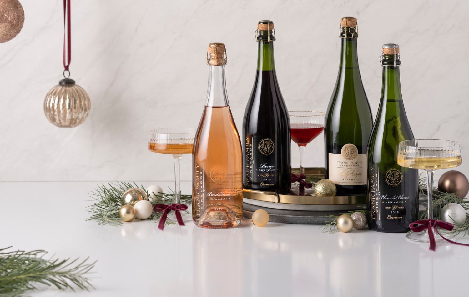 An assortment of Frank Family sparkling wines with Christmas ornaments